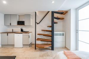 a room with a kitchen and a spiral staircase in a house at Canto Cigalo Duplex 12 in Robion en Luberon