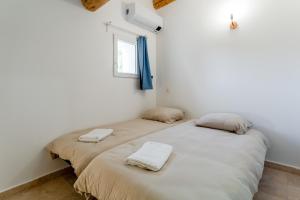 two twin beds in a room with a window at Canto Cigalo Duplex 12 in Robion en Luberon