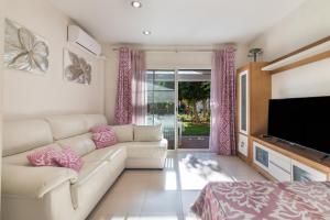 a living room with a couch and a flat screen tv at Duplex Islantilla Golf in Huelva