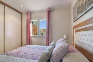 a bedroom with a bed and a window at Duplex Islantilla Golf in Huelva +17 photos