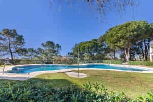 a swimming pool in a yard with trees at Duplex Islantilla Golf in Huelva