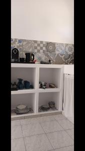 a kitchen with white shelves with plates and dishes at Pico Bello Patmos 26 in Patmos +26 photos