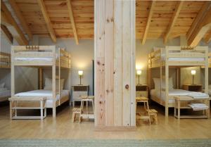 two bunk beds in a room with wooden ceilings at El Albergue Rural in Mombeltrán