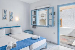 a bedroom with two beds and a tub and a window at Pico Bello Patmos 26 in Patmos