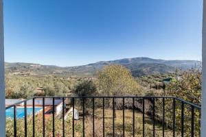 a balcony with a view of a pool and mountains at La Casa 1950 in Montefrío