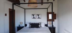 a bedroom with a canopy bed with a black frame at La Casa 1950 in Montefrío