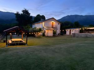 a house with a picnic table in a yard at night at El Albergue Rural in Mombeltrán