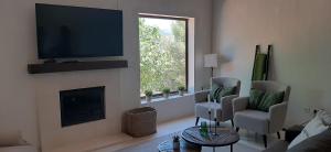 a living room with a fireplace with a flat screen tv at La Casa 1950 in Montefrío