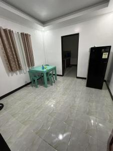 a room with a green table and a refrigerator at Yena's Inn in Cauayan +26 photos