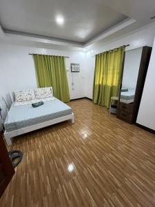 a bedroom with a bed and a wooden floor at Yena's Inn in Cauayan