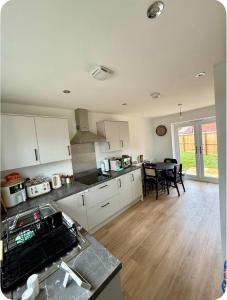 a kitchen with white cabinets and a table in it at Single room in Tamworth in Wigginton