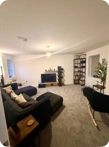 a living room with a couch and a flat screen tv at Single room in Tamworth in Wigginton