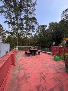 a red deck with benches and a picnic table at Silver Breeze in Yercaud
