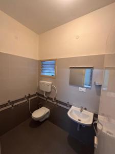 a bathroom with a toilet and a sink at Silver Breeze in Yercaud