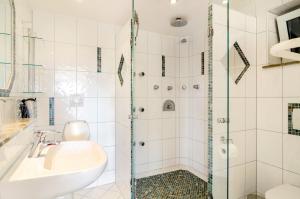 a bathroom with a sink and a shower at Ferienwohnung Gartenblick in Herdwangen-Schönach