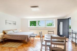 a bedroom with a bed and a table and chairs at Ferienwohnung Gartenblick in Herdwangen-Schönach