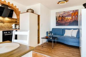a living room with a blue couch and a table at Ferienwohnung Gartenblick in Herdwangen-Schönach +42 photos