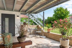 a patio with a table and chairs and plants at Ferienwohnung Gartenblick in Herdwangen-Schönach
