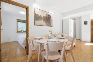a white dining room with a table and chairs at Mini Trenta in Soča +11 photos