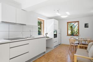 a kitchen with white cabinets and a dining room at Mini Trenta in Soča