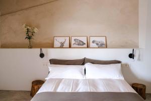 a bedroom with a bed with three pictures on the wall at Casa Comalats in Montoliu de Segarra
