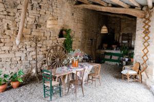a table and chairs in a room with a stone wall at Casa Comalats in Montoliu de Segarra