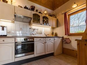 a kitchen with white cabinets and an oven at Ferienwohnung Heimatgefühl Thalheim in Leibertingen