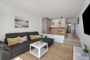 a living room with a gray couch and a kitchen at Casa Agua Y Sol I in Poris de Abona