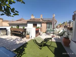 a patio with a table and chairs and a piano at Casa con terraza centro Granada y vistas Alhambra in Granada