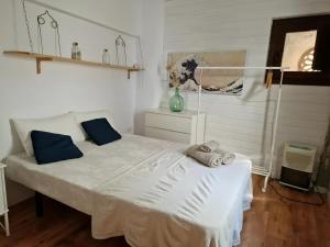 a bedroom with a large white bed with blue pillows at Casa con terraza centro Granada y vistas Alhambra in Granada