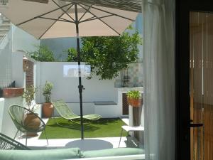 a patio with an umbrella and a table and chairs at Casa con terraza centro Granada y vistas Alhambra in Granada