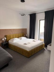a large bed in a bedroom with a window at Pensiunea LOFT Căciulata in Caciulata +34 photos