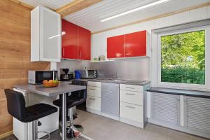 a kitchen with red cabinets and a table and a window at Ferienhaus 202 in Zadelsdorf