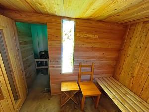 a wooden room with a chair and a window at Ferienhaus 202 in Zadelsdorf +12 photos