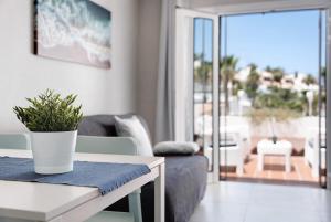 a living room with a table with a potted plant on it at Holiday Valley Blue Ocean B2 in Adeje