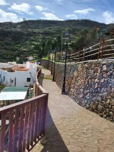 a stone wall and a street light next to a sidewalk at Casas de Vacaciones Ibaiale in Cazadores