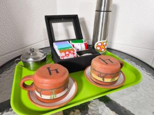 a table with two cakes on a green tray at Tilcara Hostal Niña Coya in Tilcara +26 photos