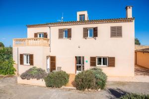 a large white house with brown shutters at Ca Na Bergues in Ariany