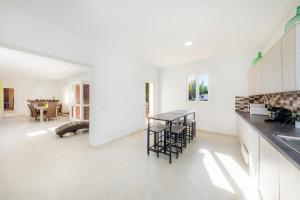 a kitchen with white walls and a table and chairs at Ca Na Bergues in Ariany