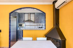 a kitchen with yellow walls and a stove at Mimosa in L'Escala