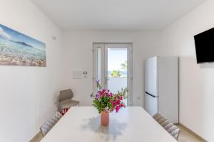 a white room with a table and a refrigerator at Residence Fronte Mare in Ugento