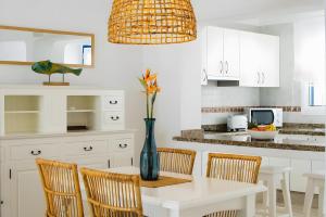 a kitchen with a table with chairs and a vase at Bungalow 5 - Caleta Campos in Arrieta