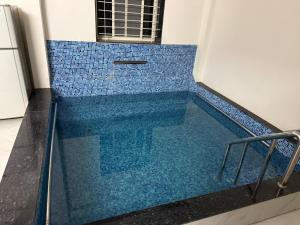 a swimming pool with blue tile in a room at Nahta's Farm Villa in Simrol