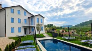 a villa with a swimming pool and a house at Dolce Bacio in Valdobbiadene