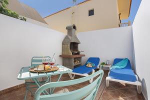 a patio with a table and chairs and a fireplace at Neral relax in Las Playitas