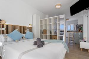 a bedroom with a large white bed with blue pillows at Neral relax in Las Playitas
