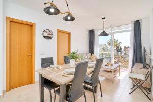 a dining room and living room with a table and chairs at Marina De El Morche in Torrox +16 photos
