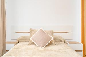 a bed with a pillow on top of it at Marina De El Morche in Torrox