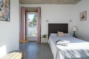 a bedroom with a bed and a chair and a window at Casa Cándido in Ribarteme +28 photos