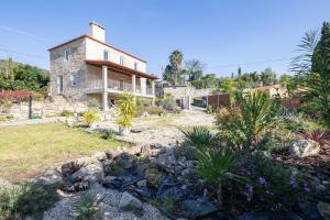 a stone house with a garden in front of it at Casa Cándido in Ribarteme